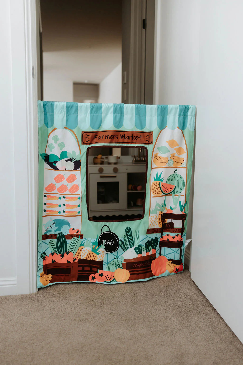 The Cozy Cube pretend play panel with ice cream shop and farmers market scenes