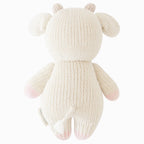 Back view of Cuddle+Kind baby cow hand knit stuffed toy showing rounded ears, tail and knit texture
