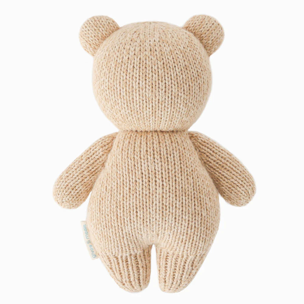 Back view of Cuddle+Kind baby honey bear hand knit stuffed toy showing rounded ears and knit texture