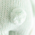 Close up of Cuddle+Kind baby bunny plush toy showing textured knit fabric and stitching details