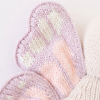 Close up of Cuddle+Kind baby butterfly plush toy showing embroidered face and patterned wings