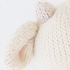 Close up of Cuddle+Kind baby cow showing textured hand knit fabric and stitched details