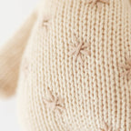 Close up of Cuddle+Kind baby giraffe showing textured hand knit fabric, stitched details and gentle spots