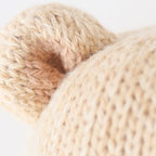 Close up of Cuddle+Kind baby honey bear showing textured hand knit fabric and stitching details