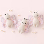 Cuddle+Kind baby butterfly knit plush toy styled with matching hand knit baby animals in nursery setting