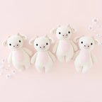 Cuddle+Kind baby cow knit plush toy styled with coordinating hand knit baby animals in a pastel nursery setting
