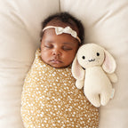 Baby cuddling Cuddle+Kind baby bunny soft knit plush toy during playtime