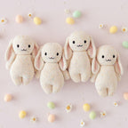 Cuddle+Kind baby bunny (confetti) plush toys arranged together with matching hand knit animal friends in nursery setting