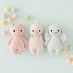 Cuddle+Kind baby bunny knit plush toy styled with matching hand knit baby animals in pastel nursery setting