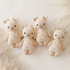 Cuddle+Kind baby giraffe knit plush toy styled with coordinating hand knit baby animals in a pastel nursery setting
