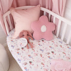Mermaid organic fitted cot sheet styled on a nursery cot with pink bedding creating a soft under the sea themed baby room
