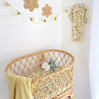Sunny Citrus bassinet sheet by Snuggle Hunny on a baby bassinet showing soft organic cotton fabric and cheerful lemon pattern