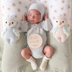 Baby cuddling Cuddle+Kind baby parrot soft knit plush toy during playtime in nursery