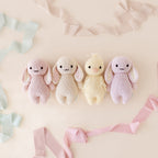 Cuddle+Kind baby bunny knit plush toy styled with matching hand knit baby animals in neutral nursery setting