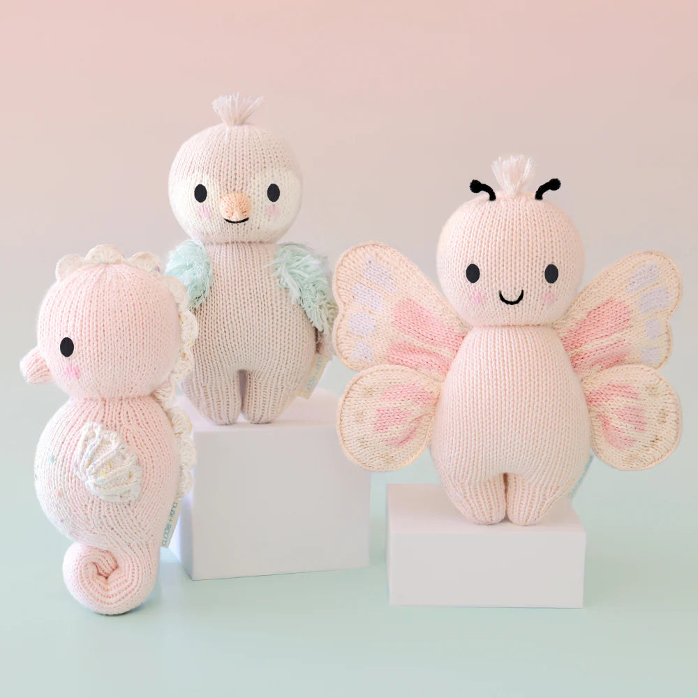 Cuddle+Kind hand knit baby animal plush toy collection displayed together in soft pastel colours
