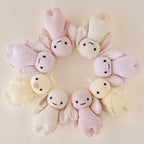 Cuddle+Kind baby duckling knit plush toy styled with coordinating hand knit baby animals in a pastel nursery setting