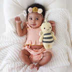 Baby cuddling Cuddle+Kind baby bee soft knit plush toy during playtime