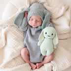 Baby cuddling Cuddle+Kind baby bunny soft knit plush toy during playtime