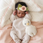 Baby cuddling Cuddle+Kind baby gosling soft knit plush toy during playtime