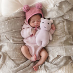 Baby cuddling Cuddle+Kind baby hippo soft knit plush toy during playtime