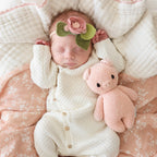 Baby cuddling Cuddle+Kind baby piglet soft knit plush toy during playtime