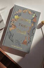 in sun Grimm’s Fairy Tales collector’s edition hardback book with illustrated cover and gold foil lettering featuring classic fairytale stories