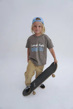 Child wearing oversized reversible tee with playground graphic