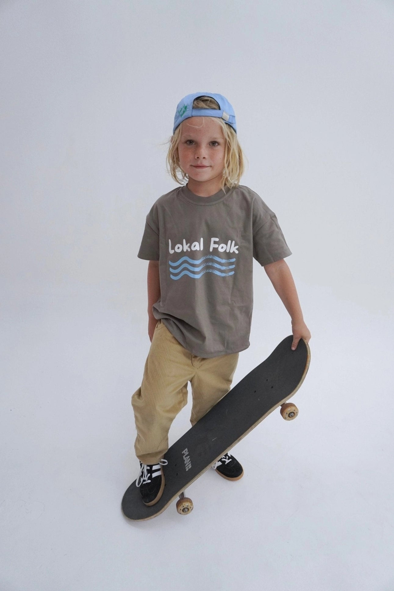 Child wearing oversized reversible tee with playground graphic