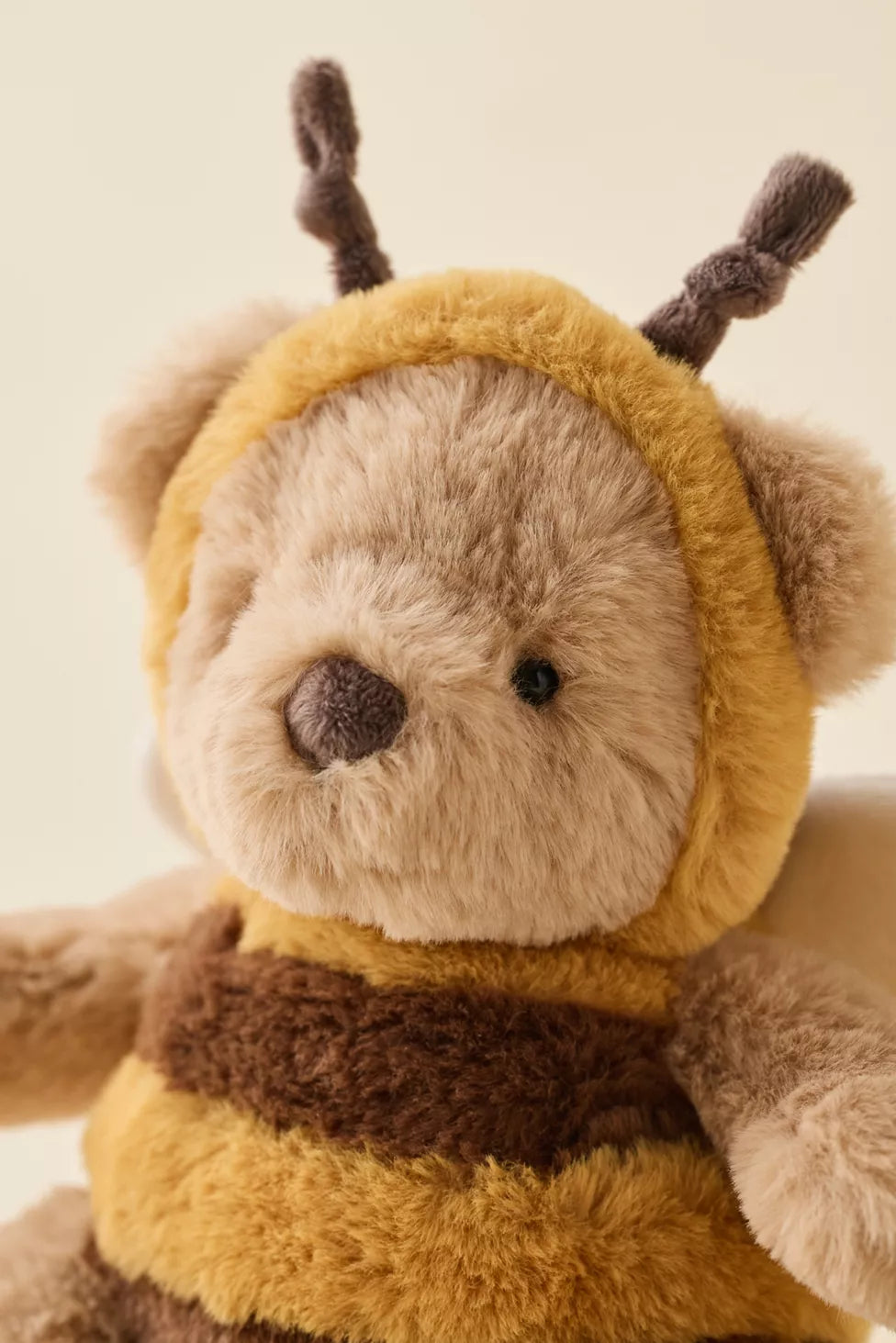 close up of bear in a honey bee costume dress up like similar to jellycat. stock image - brand is Mon Ami. very cute plushy soft toy