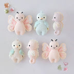 Cuddle+Kind baby butterfly knit plush toy styled with matching hand knit baby animals in pastel nursery setting. including baby seahorse (lilac), baby parrot (sky blue)