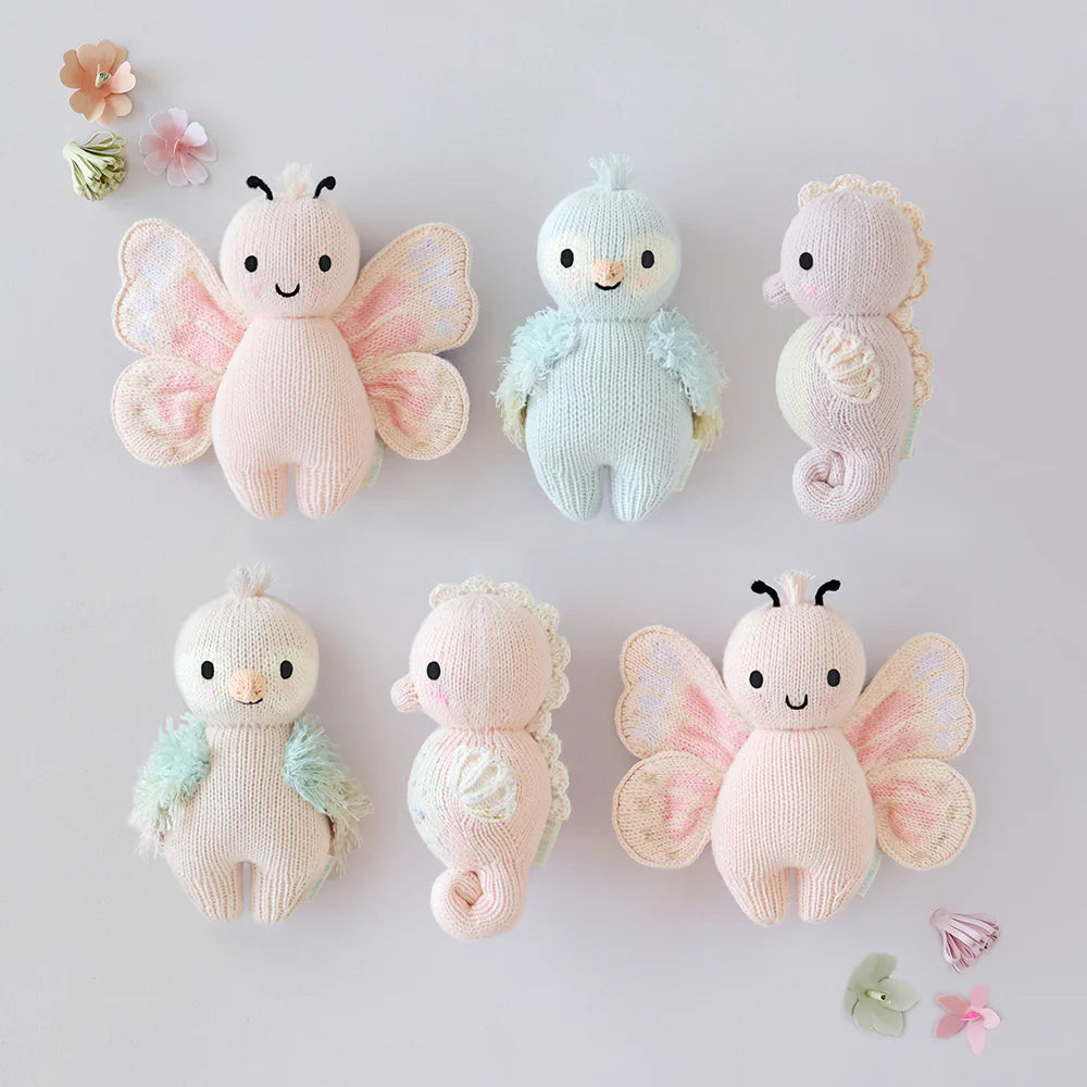 Cuddle+Kind hand knit baby animal plush toy collection displayed together in soft pastel colours
