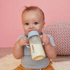 baby holding a b.box 240ml baby bottle designed for assisted and self-feeding