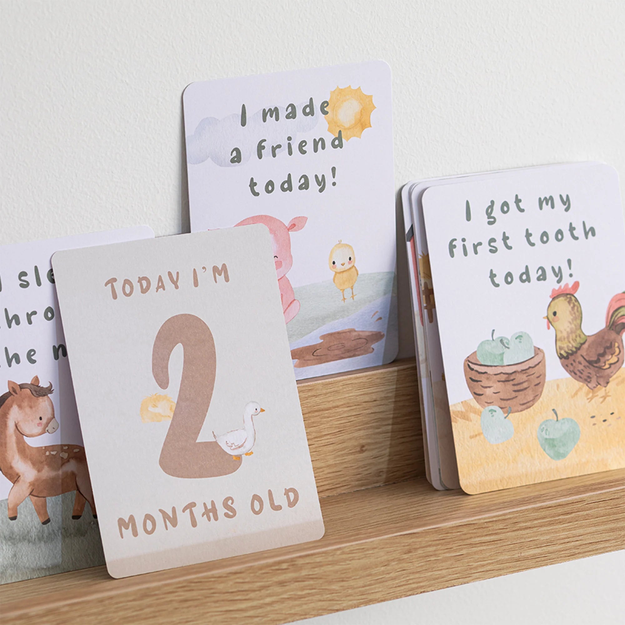 milestone cards by lively living to track babies age and milestones. great for photos and theme is tractor ride. card pictured reads i made a friend today, i got my first tooth today, today i'm 2 months old