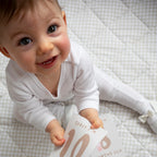 baby playing with milestone cards by lively living to track babies age and milestones. great for photos and theme is tractor ride. card pictured reads today i'm 10 months old