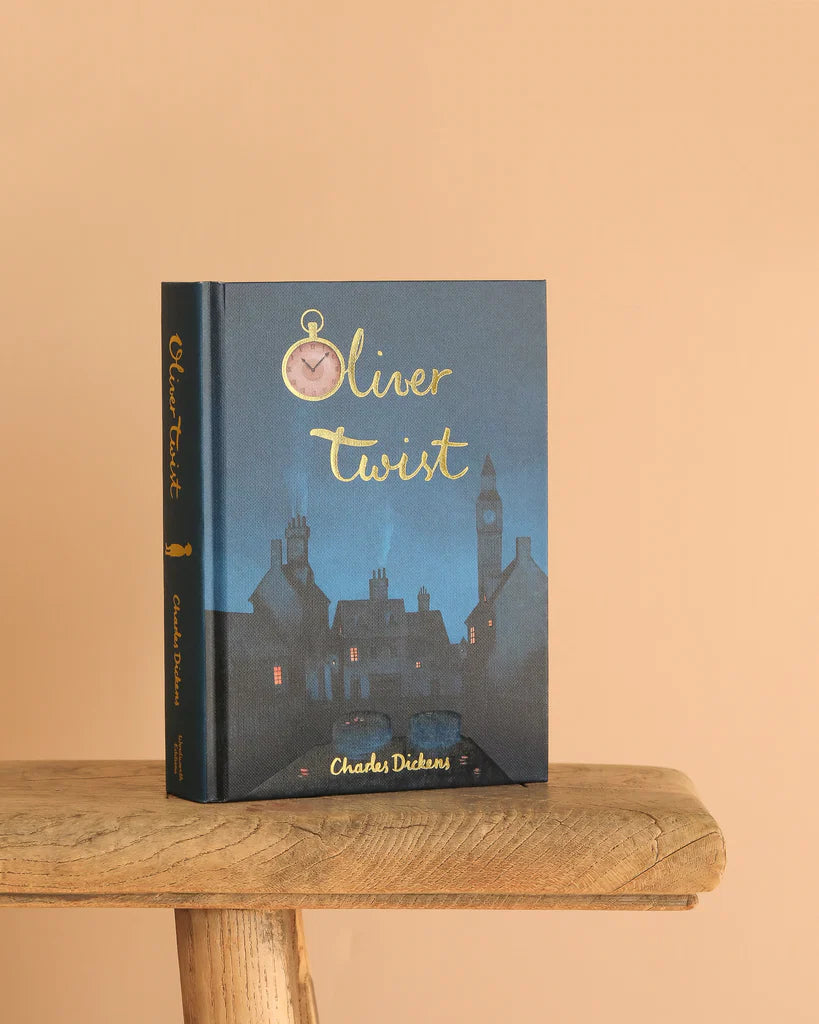  Oliver Twist collector’s edition hardcover by Charles Dickens with navy blue illustrated cover, gold foil title, cloth-bound finish.