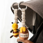Living Textiles bee and honey pot stroller toys attached to a baby pram