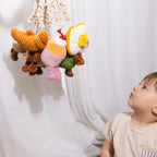 Baby reaching for Living Textiles avocado and egg stroller toys