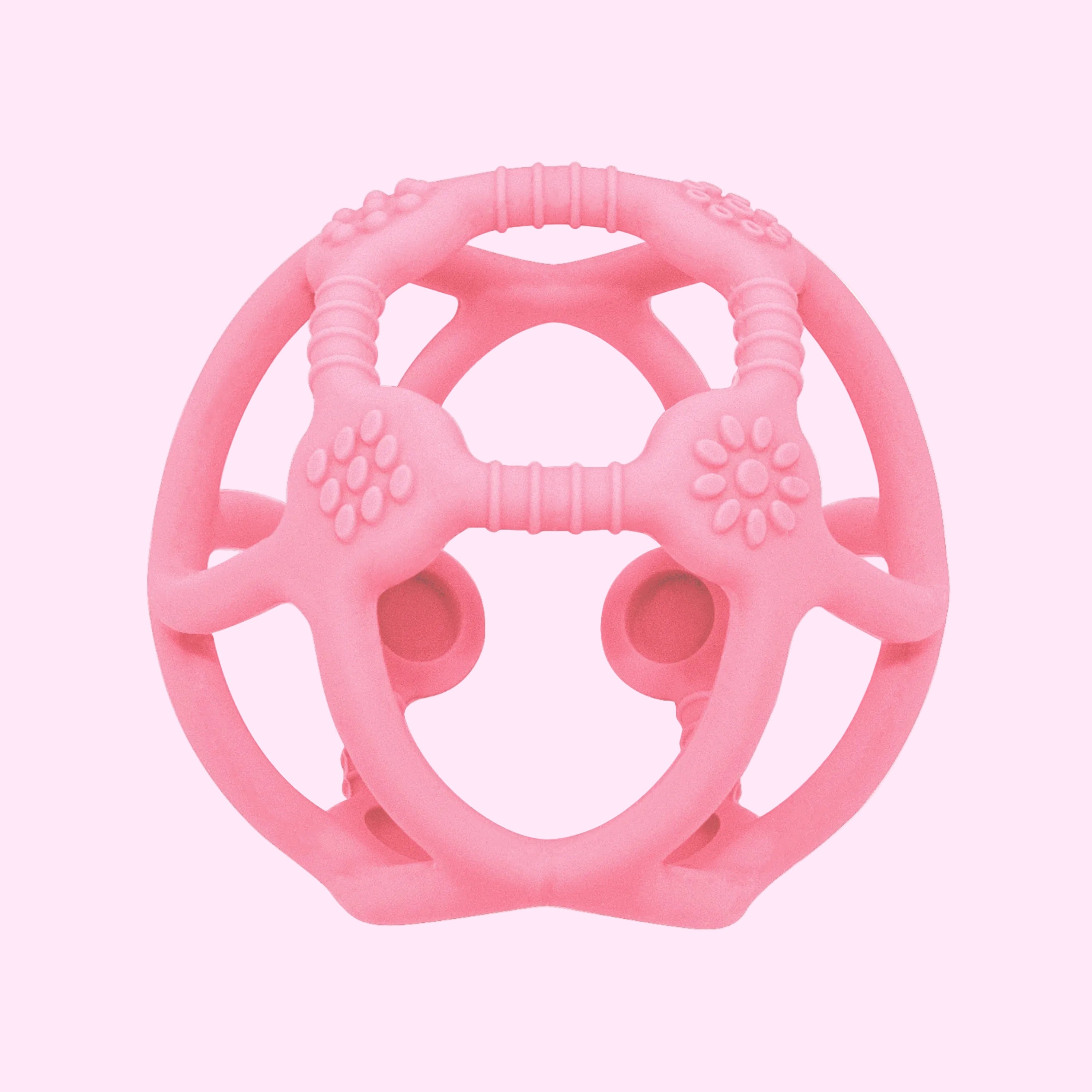 A pink textured silicone baby teether toy with a circular design, featuring textured grips, ridges, and circular suction cups on a plain white background.