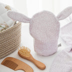 Baby grooming set with bath mitt, comb, and brush on a white surface.