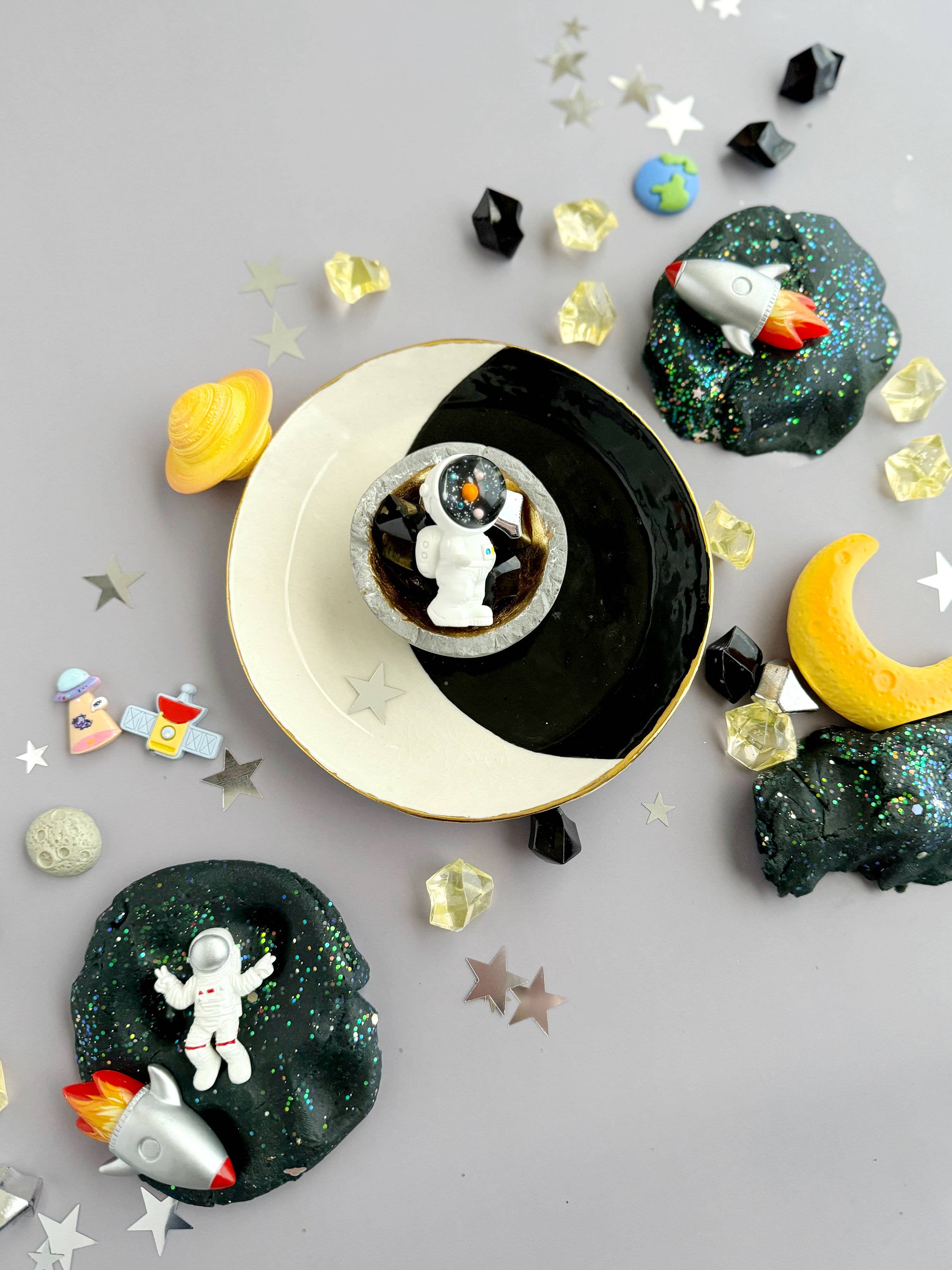 Galaxy playdough sensory set with black cherry scented dough, space glitter, astronaut toy and planet accessories arranged for hands-on tactile play