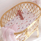 Mermaid organic bassinet sheet fitted on a woven bassinet with pink bedding creating a soft ocean themed nursery look