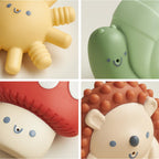 Four colorful silicone toys with cartoon faces on a light background