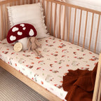 Snuggle Hunny Gnomes organic fitted cot sheet styled on a wooden nursery cot with soft bedding and woodland themed toys