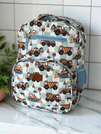 photoshoot of Mini & Mum kids backpack with insulated interior for daycare and outings. can be personalised with childs name. this print is digger dreaming. blue or sage checkers with digger construction trucks vehicles over it