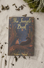 on the beach The Jungle Book children’s book by Rudyard Kipling with illustrated cover of Mowgli sitting with a black panther in a glowing jungle scene