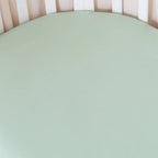 Close up of mint organic cotton jersey fitted cot sheet showing soft breathable fabric and stretch fit texture