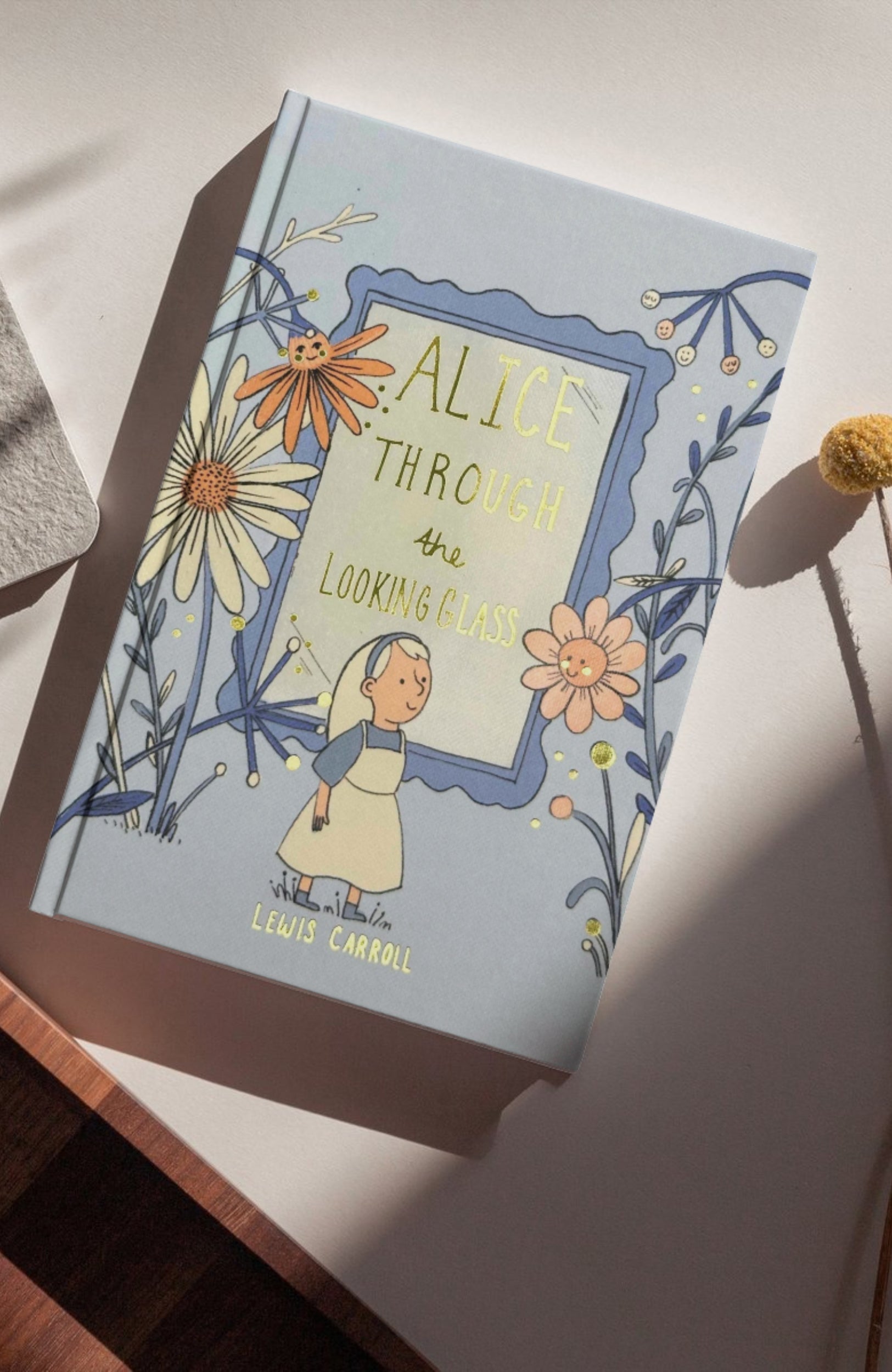 photoshoot of Alice Through the Looking-Glass collector’s edition hardback book with illustrated blue cover by Lewis Carroll wordsworth 