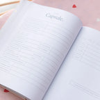 Open planner with 'The Capsule' section on a pink surface