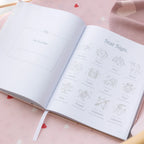 Open book with star sign illustrations on a pink surface