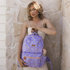 adult showing off Fox & Fallow backpack for kids, perfect for school, daycare and everyday use. Spacious, practical and designed for little adventures. Personalisation of embroidery with name also available on bags in 2 placements. This print is juniper - lilac purple with leaves with b.box drink bottle in side